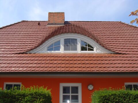 Wohnhaus mit Biberschwanz-Ziegeldach und geschwungener Fledermausgaube
